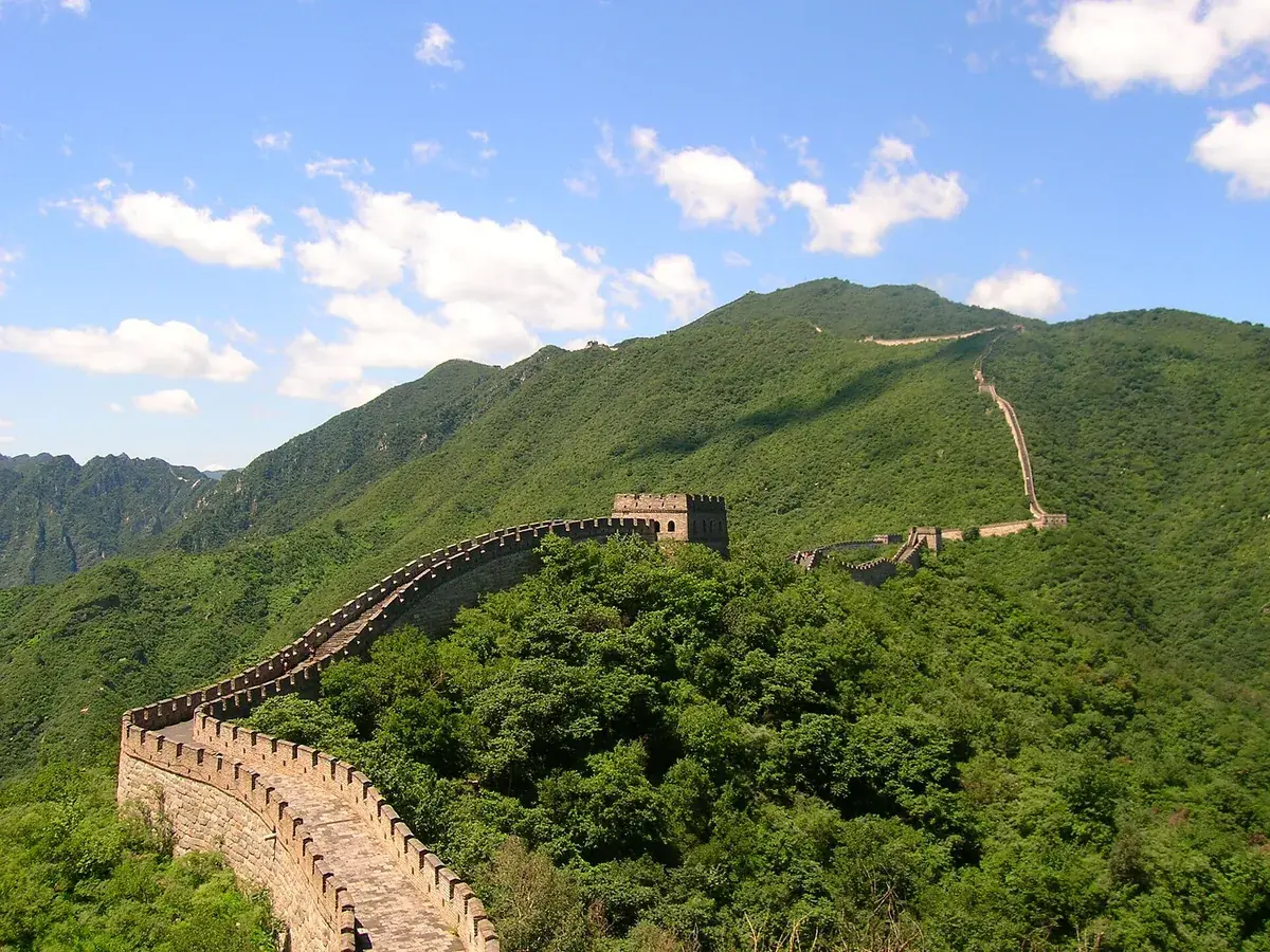 The Great Wall of China winding across forested hills