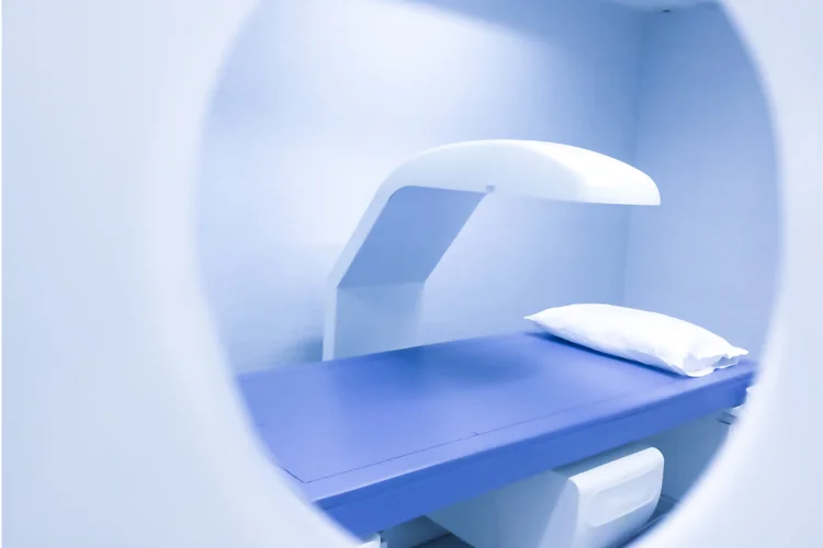 DEXA scanner with a padded table and pillow in a radiology scanning room