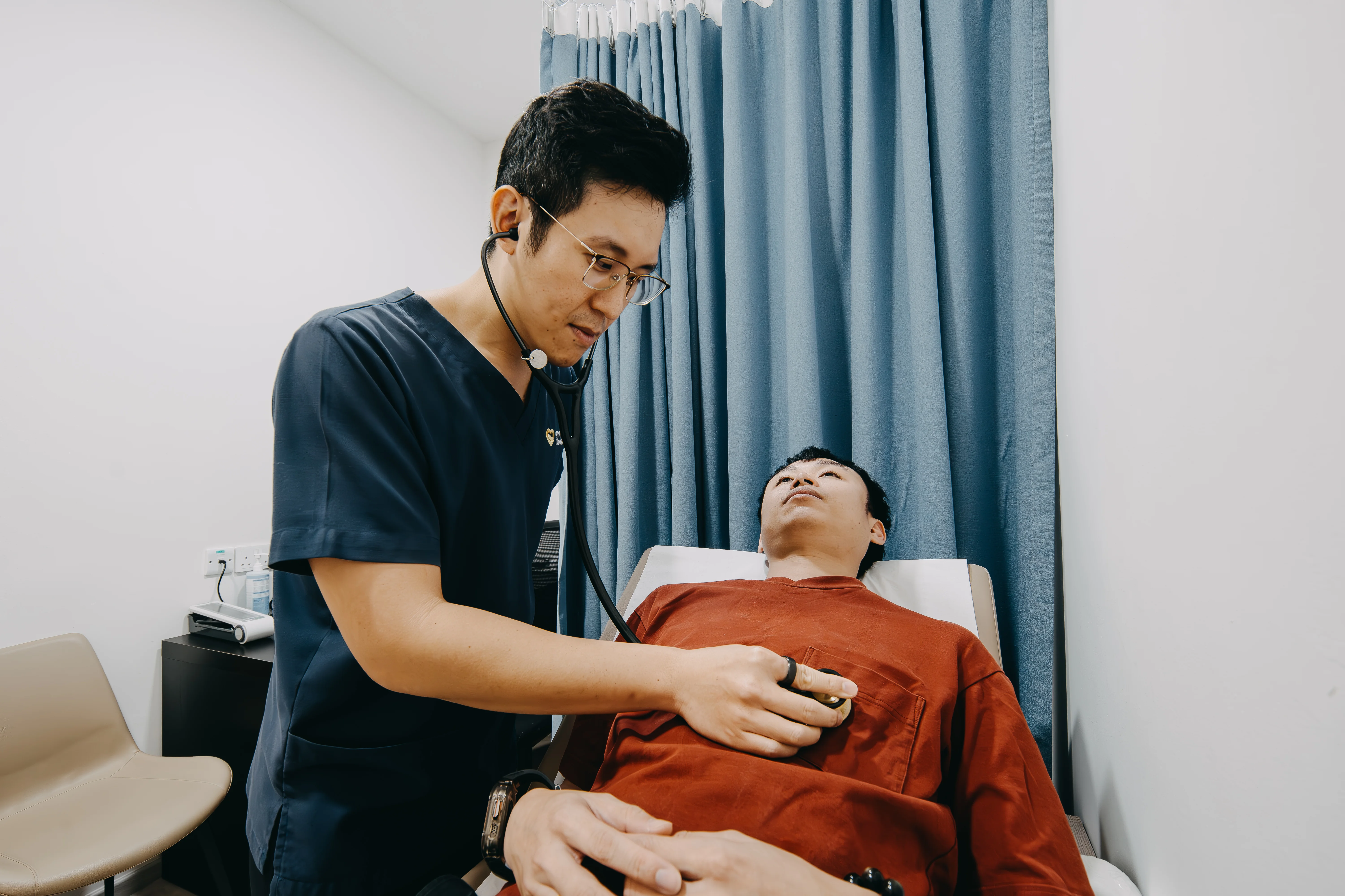 Dr Joel Foo checking a patient with a stethoscope