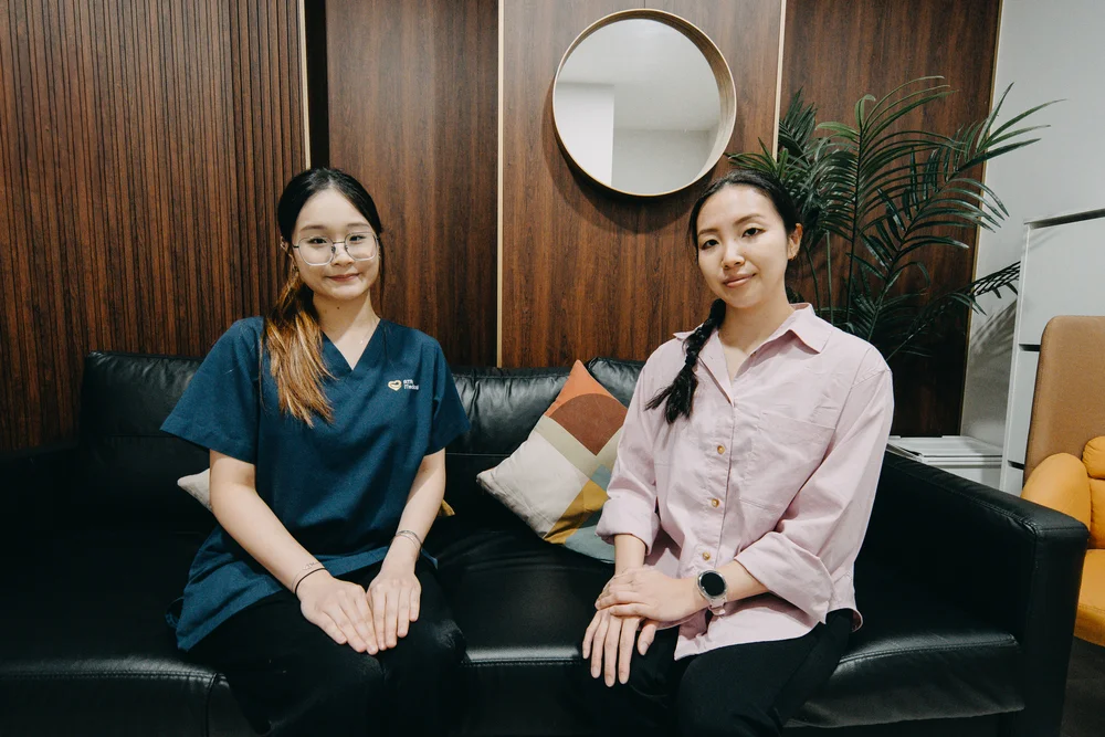Friendly ATA Medical nurse in scrubs with a relaxed patient at our STD clinic in Singapore