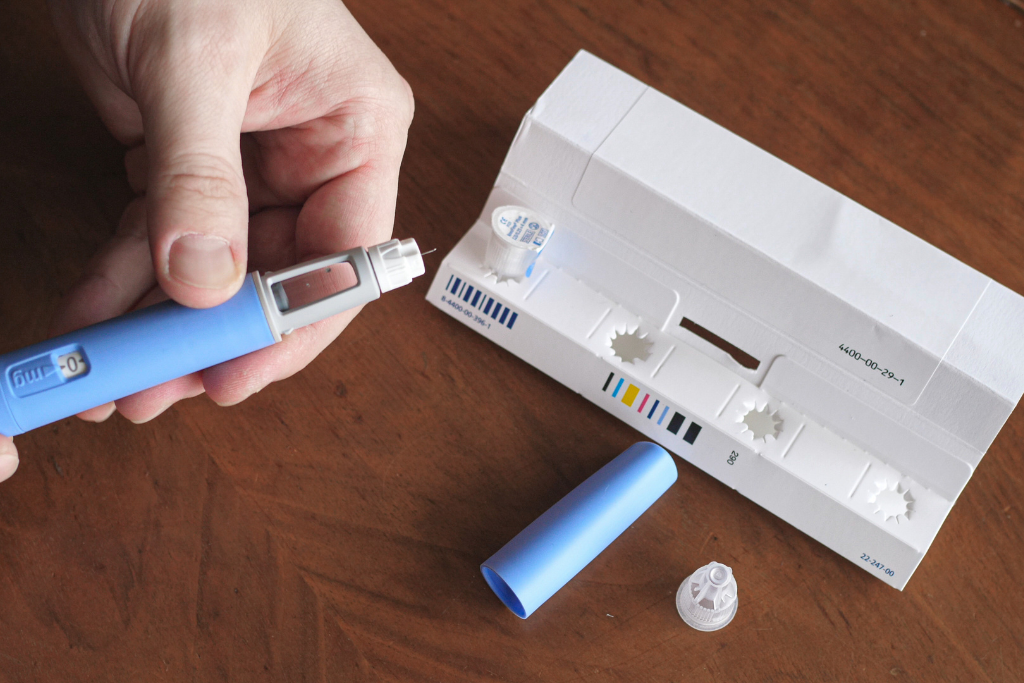 Person preparing liraglutide injection pen (Victoza, Saxenda) for managing type 2 diabetes or weight