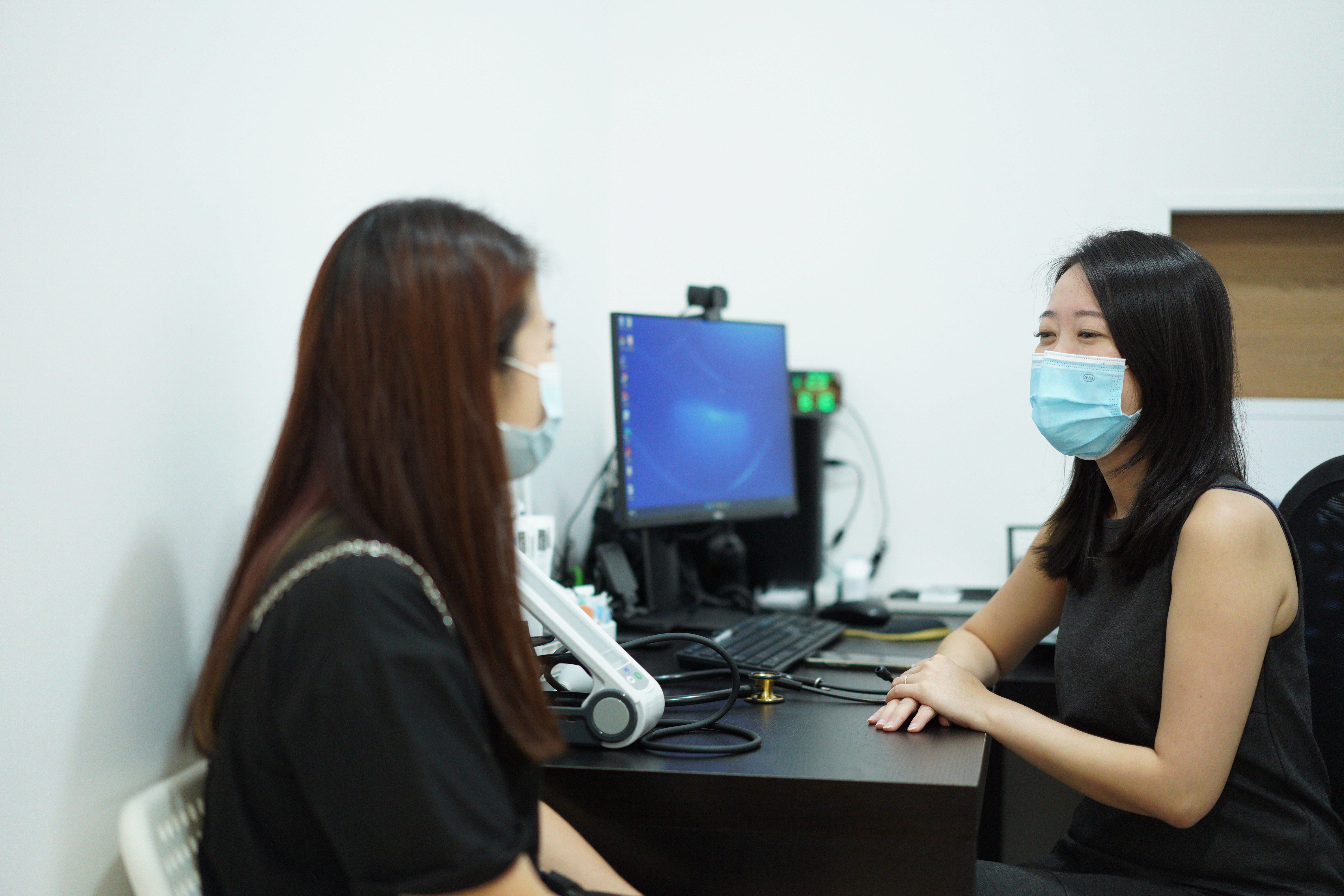 Asian woman consulting a female doctor at ATA Medical in Singapore about STD testing options.