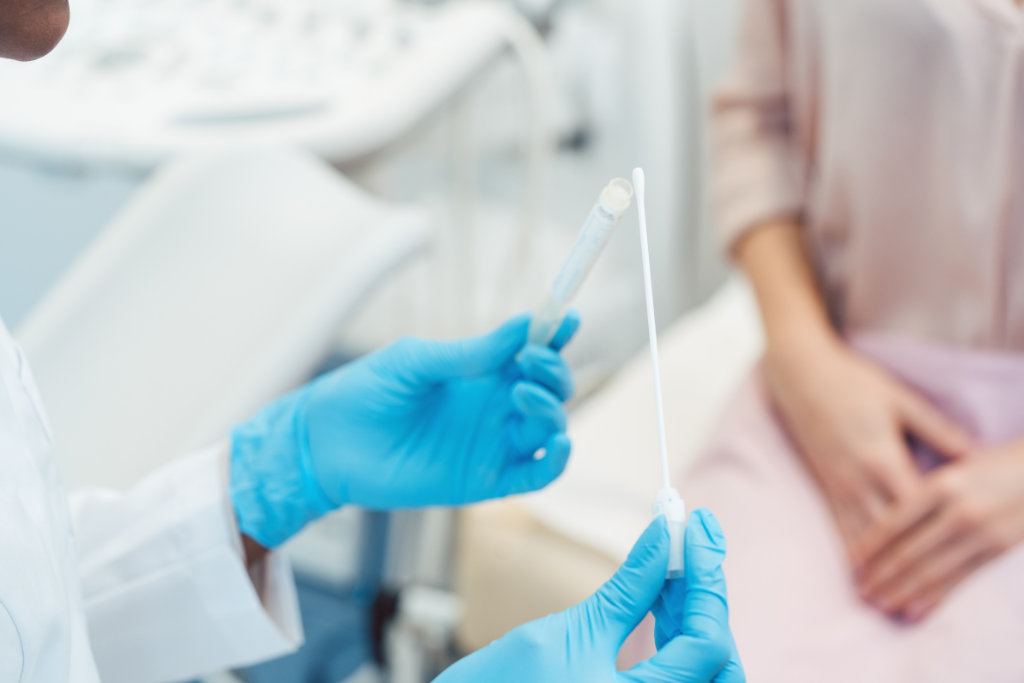 Doctor holding vaginal swab used for sample collection to test for gonorrhoea infection in patient.