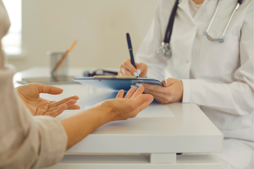 Doctor writing notes during consultation with patient for possible std exposure and risk concerns.