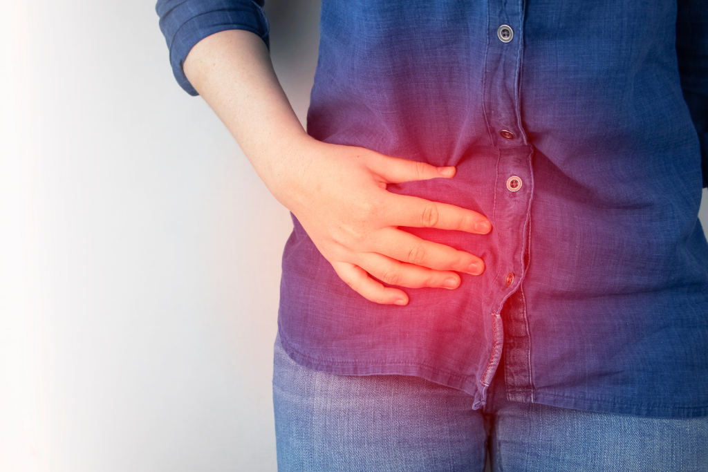 Female experiencing pain in pelvic area showing symptoms of chlamydia such as burning or discomfort.