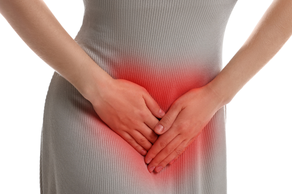 Woman clutching lower abdomen with discomfort possibly indicating gonnorhoea infection symptoms.