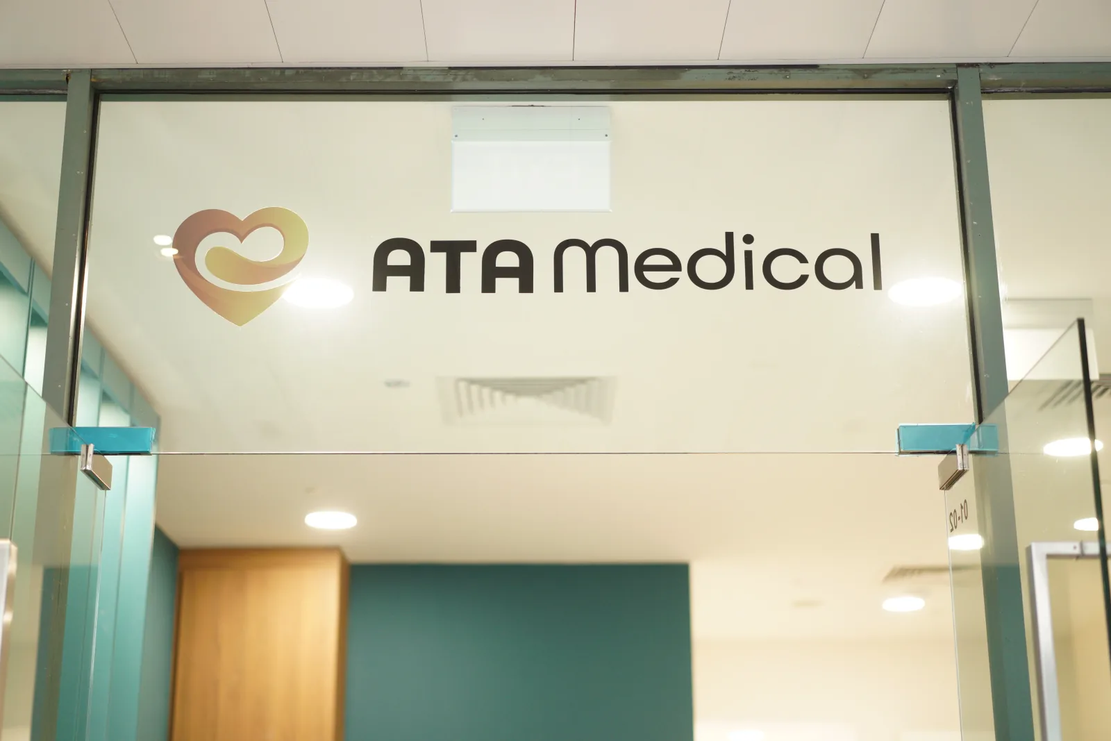 Clinic entrance with the ATA Medical heart logo on frosted glass above the doors