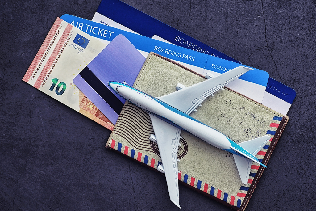 Travel documents, toy plane, and currency symbolising overseas trips and the need for travel vaccination.